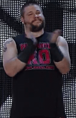 A Man With A Beard Is Wearing A Black Tank Top With The Number 10 On It And Gloves . GIF