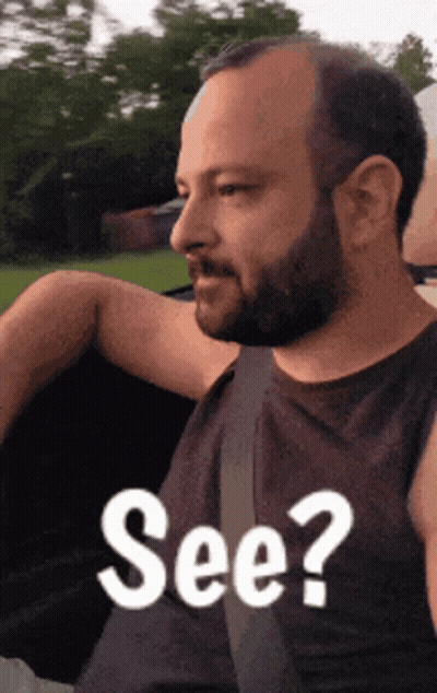 A Man With A Beard Is Wearing A Black Tank Top With The Words See On It GIF