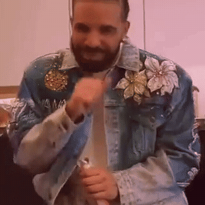 A Man With A Beard Is Wearing A Blue Denim Jacket With Flowers On The Sleeves . GIF