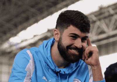 A Man With A Beard Is Wearing A Blue Hoodie With The Word City On It GIF