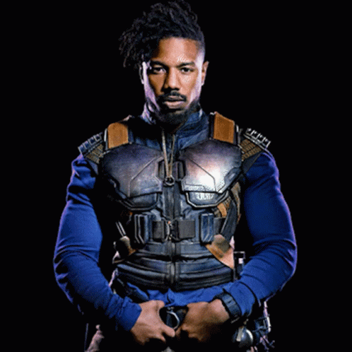 A Man With A Beard Is Wearing A Blue Shirt And A Black Jacket GIF