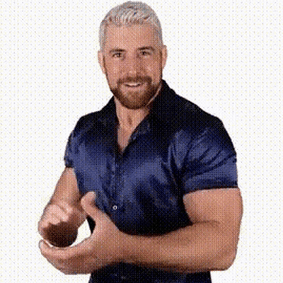 A Man With A Beard Is Wearing A Blue Shirt And Making A Funny Face . GIF