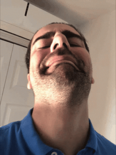 A Man With A Beard Is Wearing A Blue Shirt And Making A Funny Face GIF