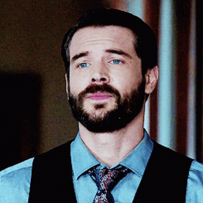 A Man With A Beard Is Wearing A Blue Shirt And Tie GIF