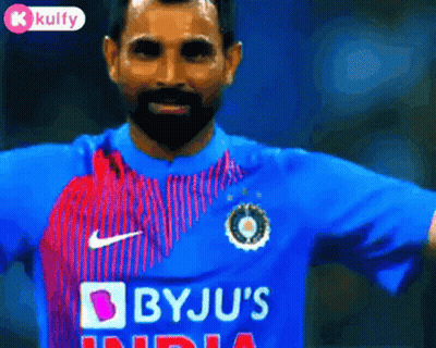 A Man With A Beard Is Wearing A Blue Shirt That Says Bju 'S India GIF