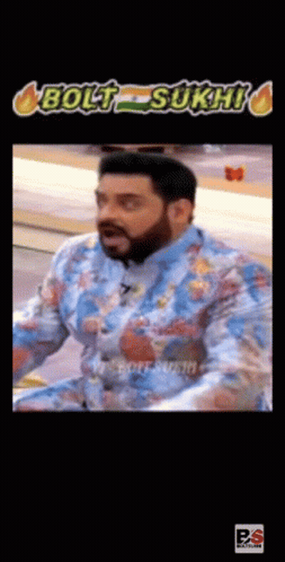 A Man With A Beard Is Wearing A Blue Shirt With A Floral Pattern And Making A Funny Face . GIF
