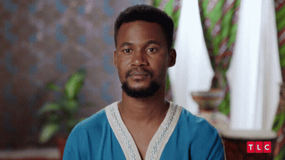 A Man With A Beard Is Wearing A Blue Shirt With The Letters Tlc On It GIF