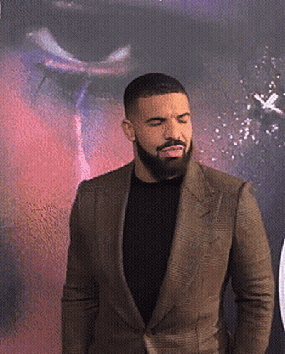 A Man With A Beard Is Wearing A Brown Suit GIF