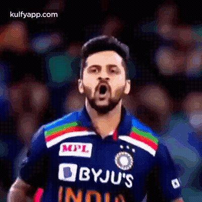 A Man With A Beard Is Wearing A Byju 'S India Jersey And Making A Funny Face . GIF