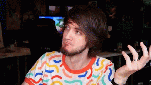 A Man With A Beard Is Wearing A Colorful Shirt With A Pattern Of Swirls On It GIF