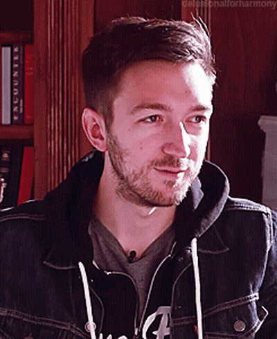 A Man With A Beard Is Wearing A Denim Jacket And A Hoodie GIF
