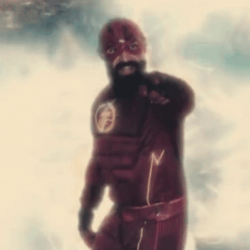 A Man With A Beard Is Wearing A Flash Suit And Pointing . GIF
