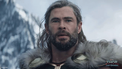 A Man With A Beard Is Wearing A Fur Coat With The Word Thor On It GIF