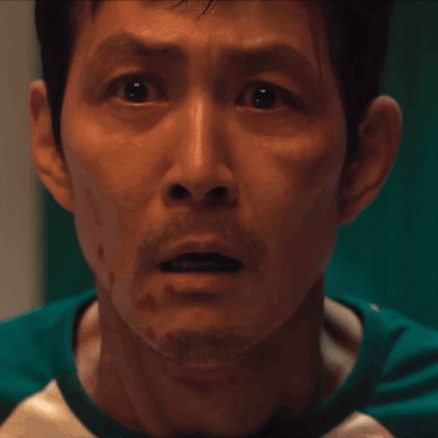 A Man With A Beard Is Wearing A Green And White Shirt GIF