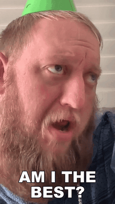 A Man With A Beard Is Wearing A Green Party Hat And Says Am I The Best GIF