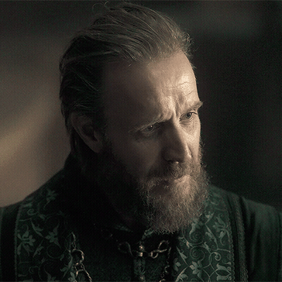 A Man With A Beard Is Wearing A Green Shirt With A Chain Around His Neck GIF