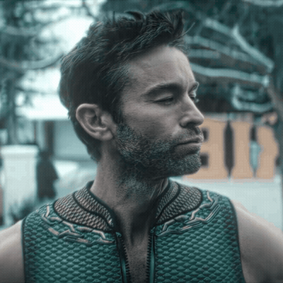 A Man With A Beard Is Wearing A Green Vest With A Zipper GIF