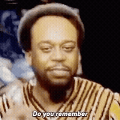 A Man With A Beard Is Wearing A Hat And A Striped Shirt And Is Asking Do You Remember . GIF