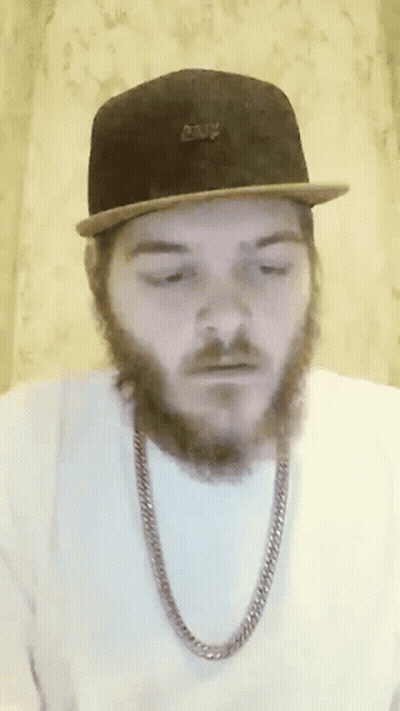 A Man With A Beard Is Wearing A Hat And Chain GIF