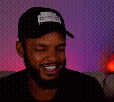 A Man With A Beard Is Wearing A Hat And Making A Funny Face With His Eyes Closed . GIF