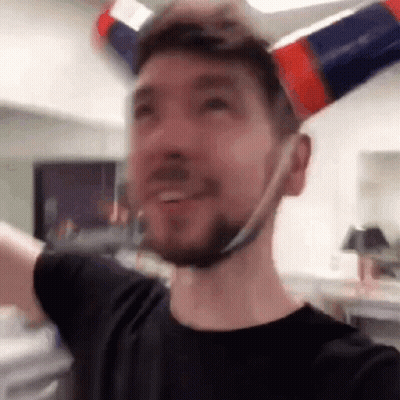 A Man With A Beard Is Wearing A Hat Made Out Of A Bottle . GIF