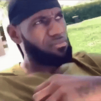 A Man With A Beard Is Wearing A Headband And A Bandana . GIF