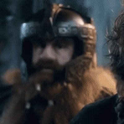 A Man With A Beard Is Wearing A Helmet And A Fur Hood . GIF