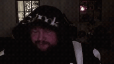 A Man With A Beard Is Wearing A Hoodie And Headphones And Making A Funny Face . GIF