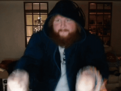 A Man With A Beard Is Wearing A Hoodie And Headphones GIF