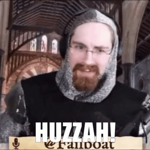 A Man With A Beard Is Wearing A Knight 'S Armor And Has The Word Huzzah On His Face GIF