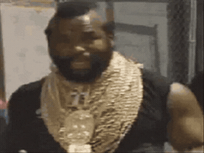 a man with a beard is wearing a lot of gold necklaces around his neck .