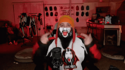 A Man With A Beard Is Wearing A Mask And A Hoodie That Says Gang Angel GIF