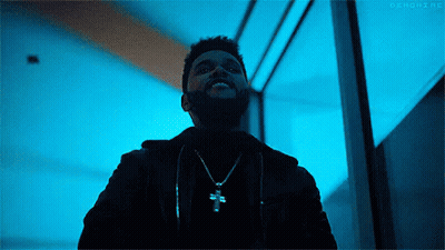 A Man With A Beard Is Wearing A Necklace With A Cross On It And Smiling . GIF