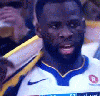 A Man With A Beard Is Wearing A Nike Jersey While Watching A Game . GIF