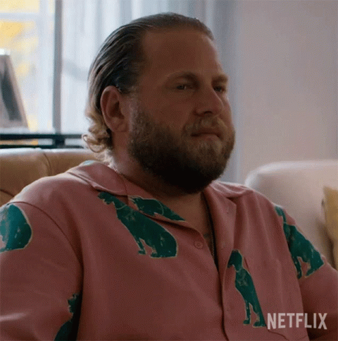 A Man With A Beard Is Wearing A Pink Shirt With Bears On It GIF