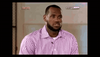 A Man With A Beard Is Wearing A Purple And White Striped Shirt And Talking To A Microphone . GIF