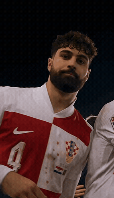 A Man With A Beard Is Wearing A Red And White Nike Shirt GIF