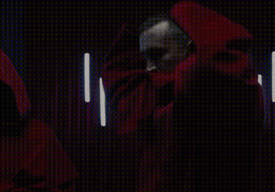 A Man With A Beard Is Wearing A Red Cape With A Hood GIF