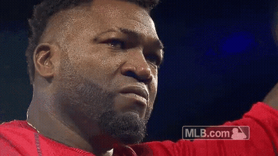 A Man With A Beard Is Wearing A Red Shirt And A Mlb.com Logo Is Behind Him GIF