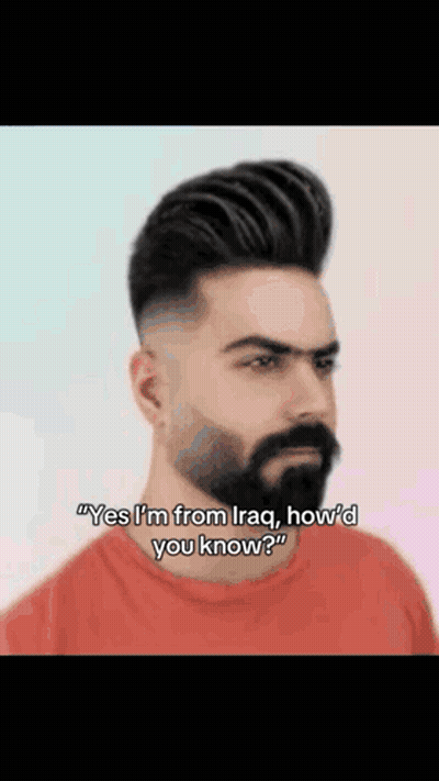 A Man With A Beard Is Wearing A Red Shirt And Talking To Someone . GIF