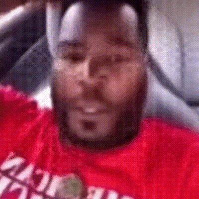A Man With A Beard Is Wearing A Red T-Shirt That Says ' Miami ' On It . GIF