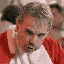 A Man With A Beard Is Wearing A Santa Claus Outfit And Making A Funny Face . GIF