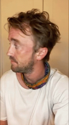 A Man With A Beard Is Wearing A Scarf Around His Neck GIF
