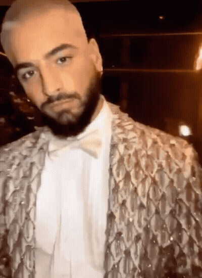 A Man With A Beard Is Wearing A Sequined Jacket And A Bow Tie GIF
