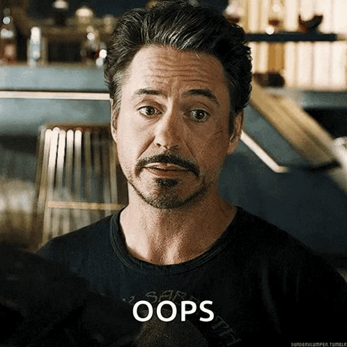A Man With A Beard Is Wearing A Shirt That Says Oops On It GIF