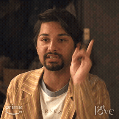 A Man With A Beard Is Wearing A Striped Jacket And A T-Shirt That Says Rye On It . GIF