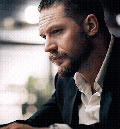 A Man With A Beard Is Wearing A Suit And A White Shirt . GIF
