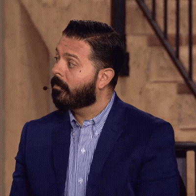 A Man With A Beard Is Wearing A Suit And Striped Shirt GIF