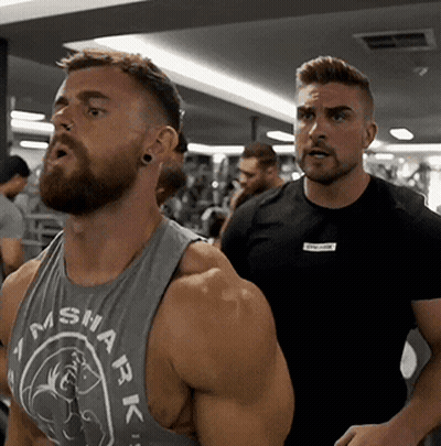 A Man With A Beard Is Wearing A Tank Top That Says Shark On It GIF