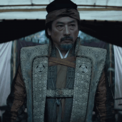 A Man With A Beard Is Wearing A Vest With A Circle On The Front GIF